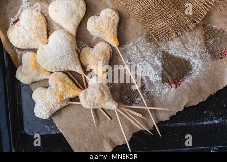 A forma di cuore jam-riempito di biscotti su bastoni Foto Stock