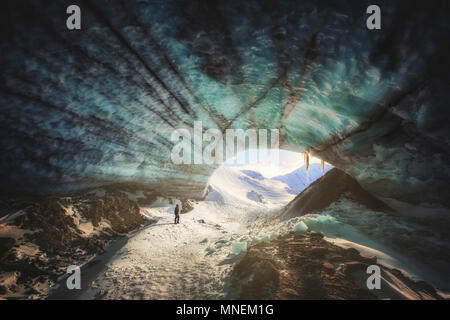 La grotta di ghiaccio di tramonto escursionista escursionismo congelato blu Yukon Canada montagne neve glacier Foto Stock