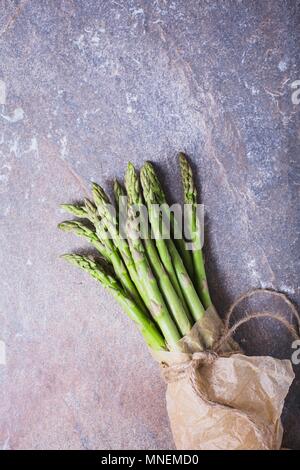 Un mazzetto di asparagi freschi spears in un sacchetto di carta legati con spago Foto Stock