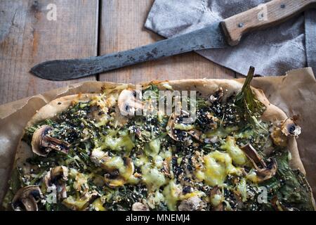 Pizza vegana con tofu, spinaci, funghi, di sesamo e di un sostituto del formaggio Foto Stock