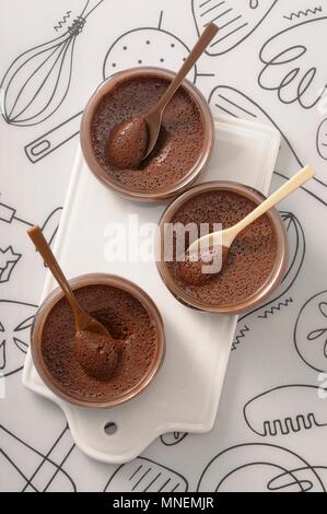 Tre ciotole di mousse al cioccolato con cucchiai Foto Stock