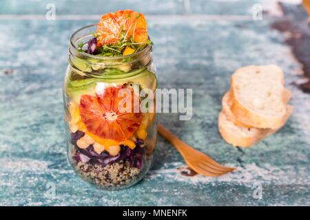 La quinoa insalata in un vasetto di vetro con cavolo rosso, ceci, avocado, Arancio sanguigno e crescione Foto Stock