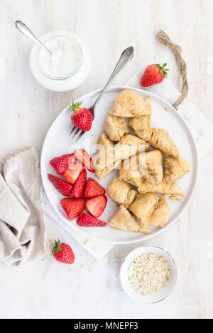 Una sana shredded frittelle di farina di farro, latte di mandorla e skyr con fragole Foto Stock