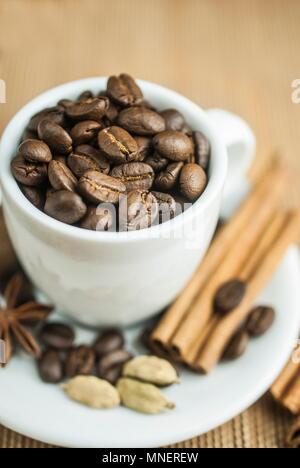 I chicchi di caffè in una tazza con spezie Foto Stock