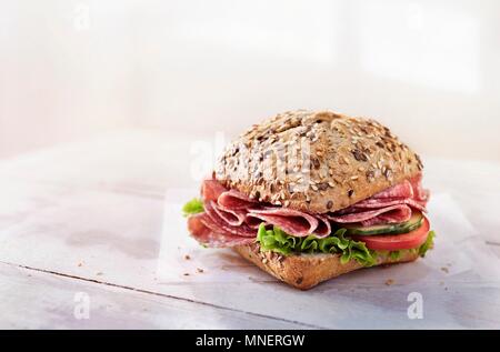 Un rullo integrale con salumi, ortaggi e lattuga Foto Stock