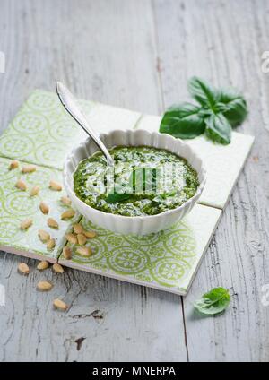 Il Pesto in una ciotola bianco; si estendesse il lato; cucchiaio Foto Stock