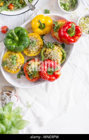 Riso e zucca peperoni ripieni cotti in un piatto bianco Foto Stock