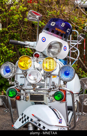 Parte anteriore di uno scooter Vespa decorata con numerosi faretti nello stile di Mods Foto Stock