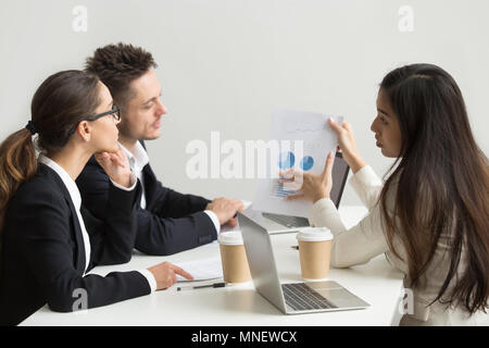 Lavoratore di sesso femminile che la presentazione di modelli visivi ai colleghi di lavoro Foto Stock