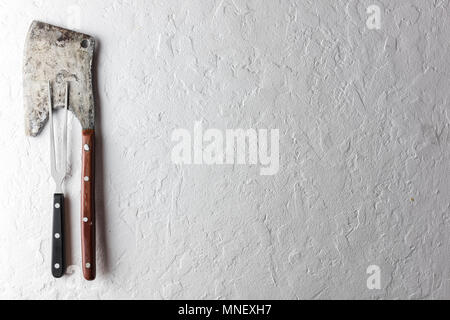 Rustici e vecchi ax per la carne su una tavola di legno Foto Stock