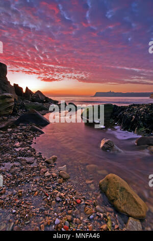 Sunrise in Scarborough North Bay, dove Scalby Beck fluisce nel mare sotto alba-Nuvole rosa Foto Stock