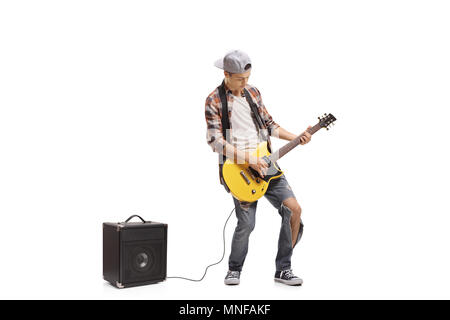 A piena lunghezza Ritratto di un ragazzo adolescente suonare chitarra elettrica collegata ad un amplificatore isolato su sfondo bianco Foto Stock