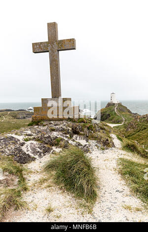 Croce e faro sull isola di Llanddwyn, Anglesey, Galles, Regno Unito Foto Stock
