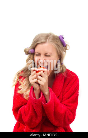 Giovane donna iniziando la sua vita vegetariana prendendo una fetta di pomodoro Foto Stock