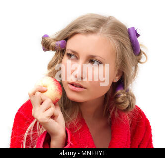 Premurosa ragazza in un accappatoio rosso con un Apple nella sua mano Foto Stock