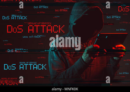 Un attacco di tipo Denial of service o di un attacco DDoS concetto con volto incappucciato persona maschio utilizzando computer tablet, basso il tasto rosso e blu immagine illuminata e digital glitch FEP Foto Stock