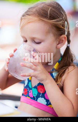 Adorabile bambina di bere acqua da un bicchiere Foto Stock