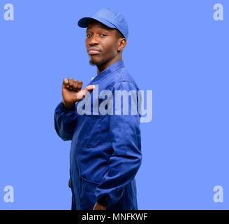 Nero Africa plumber uomo orgoglioso, eccitato e arrogante, dispositivo di puntamento con la vittoria di fronte Foto Stock