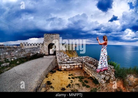 Donna di scattare foto al capo Kaliakra, Bulgaria, Mar Nero. Vecchia Fortezza abbandonata dal mare. Foto Stock