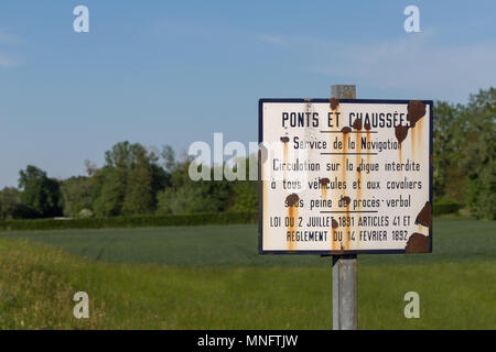 Rusty segno di francese servizi di navigazione avanti di campi e boschi Foto Stock