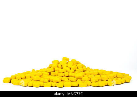 Pila di giallo-ovoidale rettangolare tablet pillole isolato su sfondo bianco con copia spazio. La medicina per il sollievo del dolore e mal di testa di emicrania. Phar Foto Stock