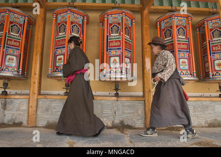 Pellegrini tibetano la filatura ruote della preghiera, Xiahe, Gansu, Cina Foto Stock