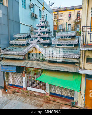 Il piccolo tempio Buddista è racchiuso a sandwich tra la zona residenziale di alta sorge in Pansodan street, Yangon, Myanmar. Foto Stock