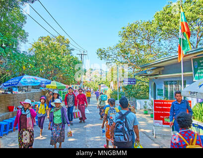 KYAIKTIYO, MYANMAR - Febbraio 16, 2018: la strada affollata lungo il pendio di montagna conduce all'ingresso Kyite Htee Yoe Pagoda - Buddhi importanti Foto Stock