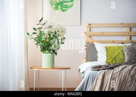 Letto moderno e piccolo comodino con mazzo di fiori in camera da letto Foto  stock - Alamy