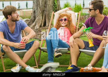 Amici rilassandovi sulle sdraio durante la giornata di sole Foto Stock