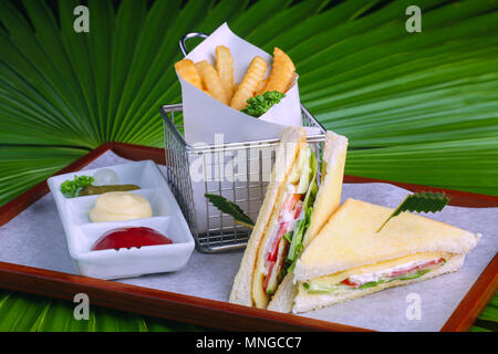 Primo piano di sandwich con tonno e verdure su pane di segale su uno sfondo di legno e Foto Stock