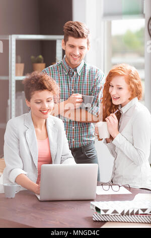 Attività creativa dei lavoratori che utilizzano computer portatile durante la preparazione di progetto Foto Stock