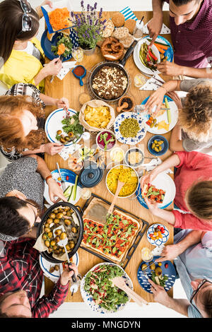 Le persone sane mangiare insieme slow food a livello comunale tabella nel ristorante con piatti sani Foto Stock