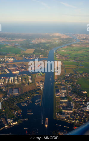 Una veduta aerea al tramonto di Westpoort, il porto di Amsterdam, Paesi Bassi, che mostra l'olio dei serbatoi di stoccaggio, le turbine eoliche e il Nordzeecanaal. Foto Stock