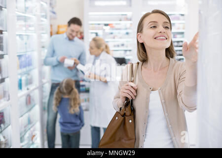 Bella donna pensieroso vagare in farmacia Foto Stock