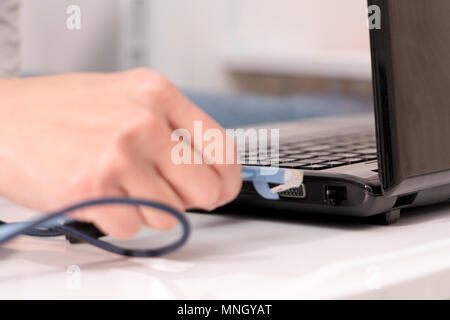 Le donne invece è di collegare il cavo LAN alla porta del laptop Foto Stock