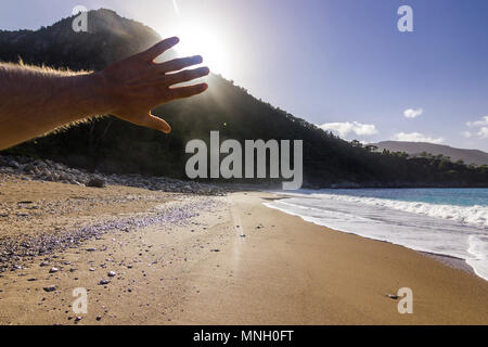 Mano sul Sun in un colorato tramonto sul mare mediterranea Foto Stock