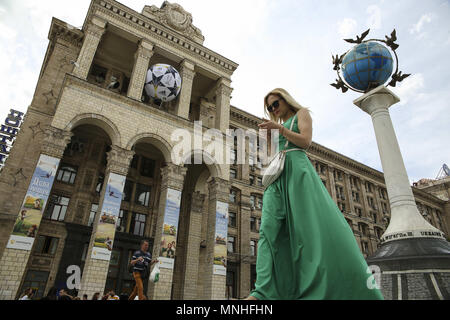 Kiev, Ucraina. Il 17 maggio 2018. Una donna cammina davanti a un ufficio postale con un enorme UEFA Champions League sfera installato su di esso in Kiev, Ucraina, 17, 2018. Kiev si prepara ad ospitare femminile UEFA per la finale di Champions League tra Wolfsburg e Lione a Valeriy Lobanovskiy Dynamo Stadium il 24 maggio 2018 e la finale di UEFA Champions League match tra il Real Madrid e il Liverpool a NSC Olimpiyskiy Stadium di sabato 26 maggio, 2018. Credito: Sergii Kharchenko/ZUMA filo/Alamy Live News Foto Stock