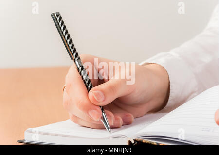 Office lady scrivere una settimana piano nella sua agenda elettronica Foto Stock