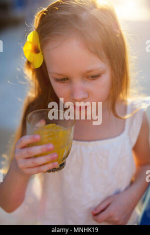 Adorabile bambina succo di bere da un bicchiere Foto Stock