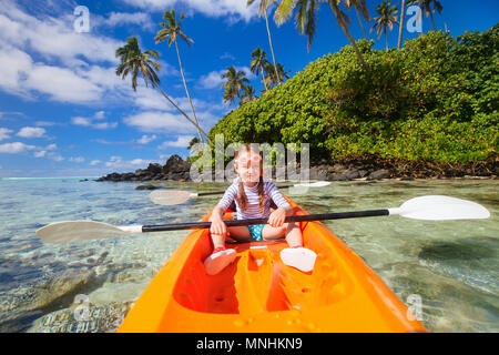 Kids godendo paddling in colorate di rosso il kayak al Tropical Ocean acqua durante le vacanze estive Foto Stock