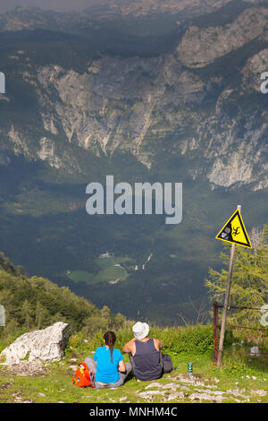 Uomo e donna con picnic e gode di vista sulle Alpi Giulie dal monte Vogel, Slovenia Foto Stock