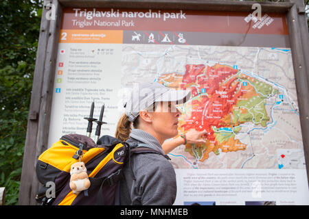 Ranger del Parco Nazionale del Triglav puntando alla mappa della zona di guida mentre il turista intorno Krn montagna nel sud-occidentale delle Alpi Giulie nel nordovest della Slovenia Foto Stock