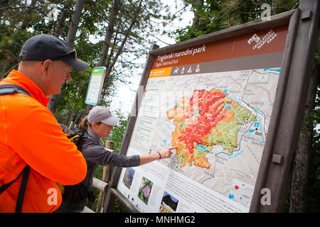 Ranger del Parco Nazionale del Triglav puntando alla mappa della zona di guida mentre il turista intorno Krn montagna nel sud-occidentale delle Alpi Giulie nel nordovest della Slovenia Foto Stock