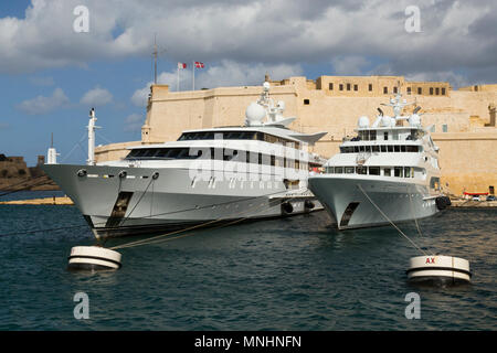 Barche e costoso private super yacht ormeggiati a Vittoriosa Yacht Marina illustrato con le fortificazioni di Birgu (Città Vittoriosa) Malta. (91) Foto Stock