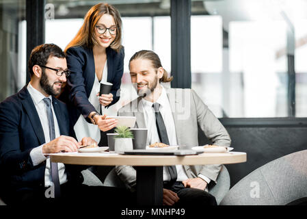 La gente di affari divertirsi seduti insieme durante la pausa caffè nella caffetteria moderna intreior Foto Stock