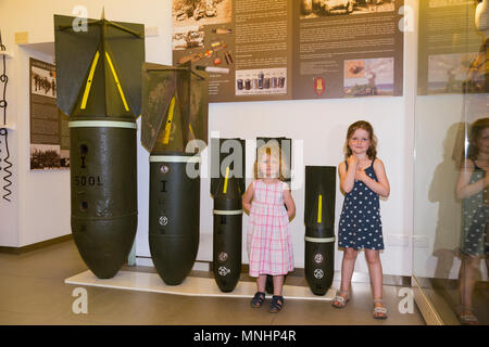 Visualizzazione delle bombe di varie dimensioni utilizzati dai paesi asse Germania & Italia contro Malta durante la Seconda Guerra Mondiale. Accompagnati da giovani bambini bambino kid kids al Museo di Guerra di Malta in Malta Foto Stock