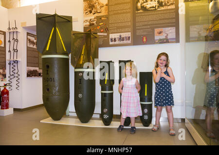 Visualizzazione delle bombe di varie dimensioni utilizzati dai paesi asse Germania & Italia contro Malta durante la Seconda Guerra Mondiale. Accompagnati da giovani bambini bambino kid kids al Museo di Guerra di Malta in Malta Foto Stock