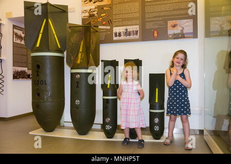 Visualizzazione delle bombe di varie dimensioni utilizzati dai paesi asse Germania & Italia contro Malta durante la Seconda Guerra Mondiale. Accompagnati da giovani bambini bambino kid kids al Museo di Guerra di Malta in Malta Foto Stock