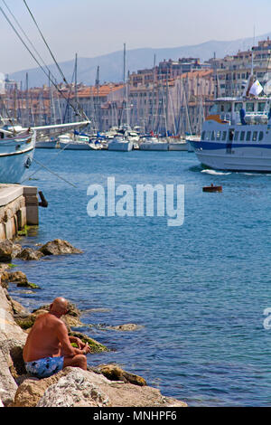 Uomo locale a prendere il sole a Porto Vecchio Vieux Port, Marseille, Bouches-du-Rhone, Provence-Alpes-Côte d'Azur, in Francia del Sud, Francia, Europa Foto Stock